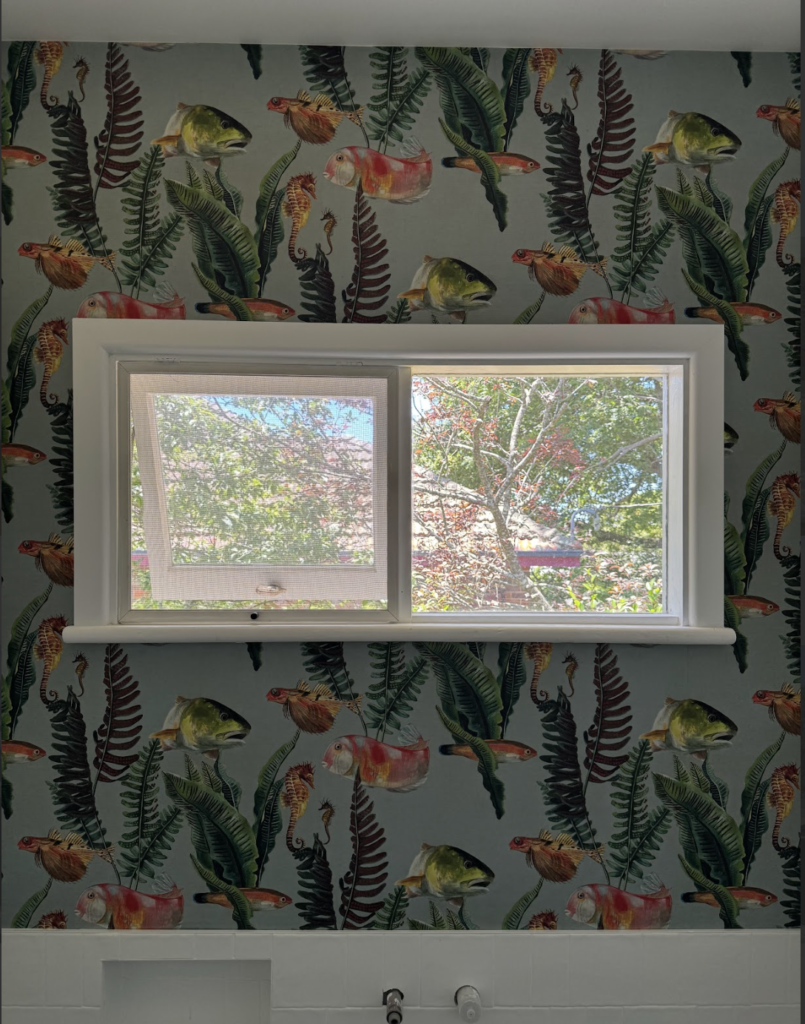 A bold ocean-themed wallpaper with fish and ferns. A great example of how affordable wallpaper in Australia can bring personality to any space without overspending.