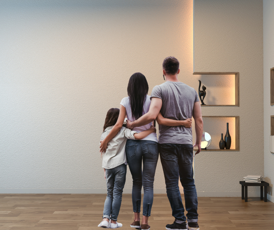 Family of 3 looking at freshly painted white wall with light brown timber floors