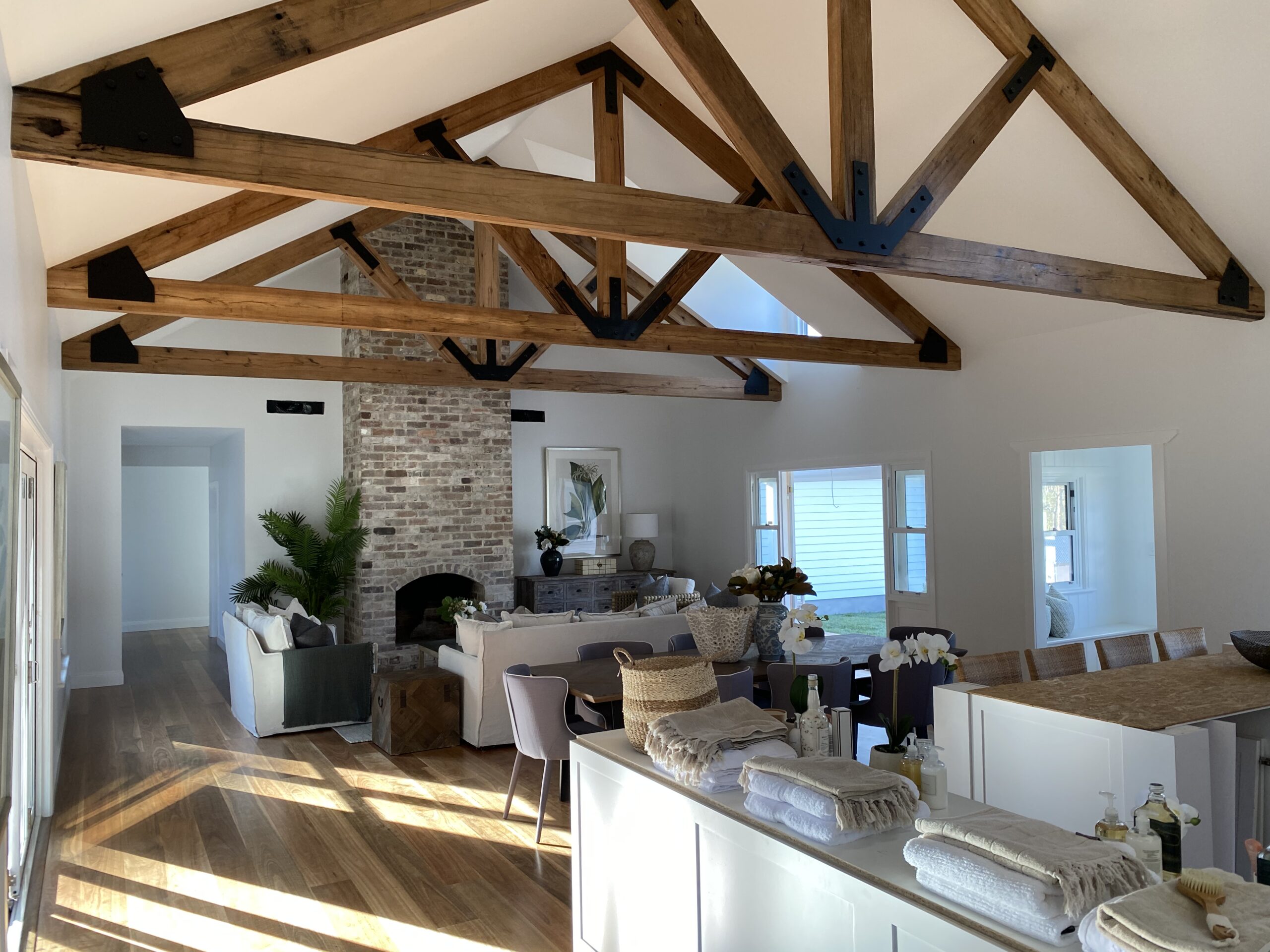 A white living room with brown timber panels and a brick feature wall
