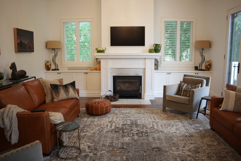 Interior living room freshly painted white with fireplace and a combination of couches and single lounge chairs