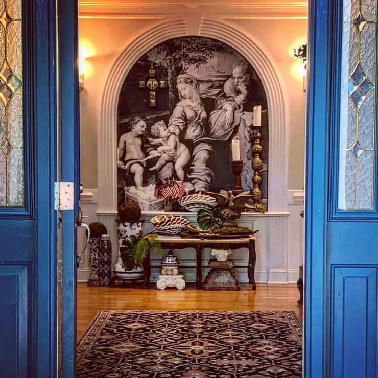 Front entrance to heritage home with framed wallpaper immediately as you walk in.